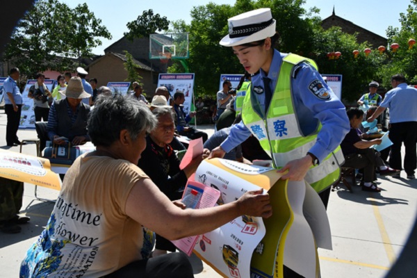 宣传民警为群众发放交通安全知识挂画.jpg